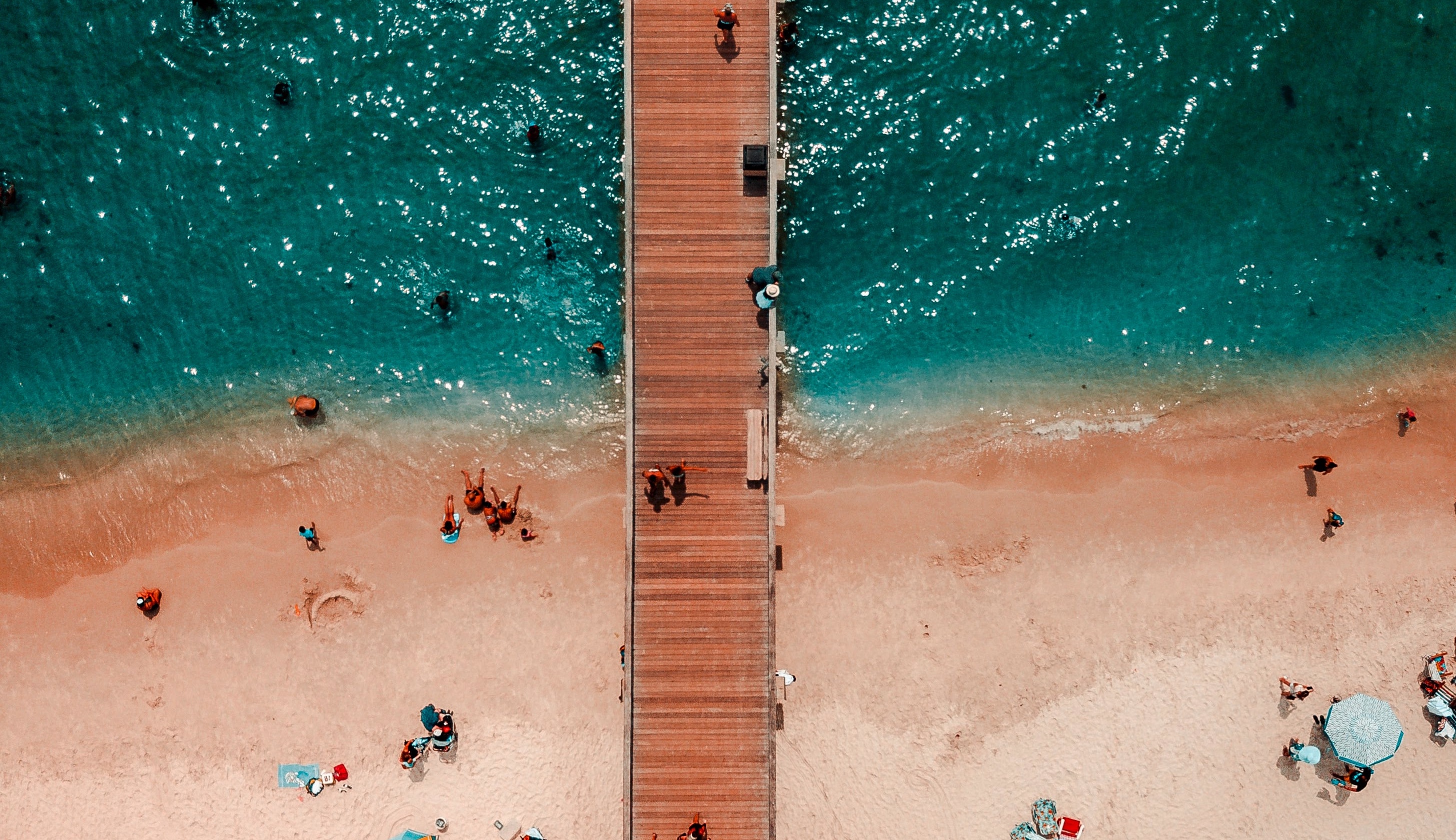 Wooden pathway leading from the beach into the ocean to showcase smooth transition to automation
